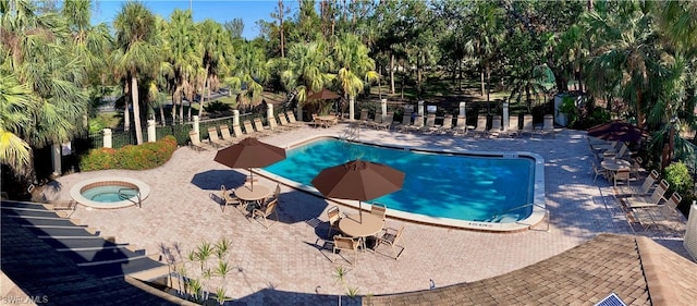 view of swimming pool with a hot tub and a patio area