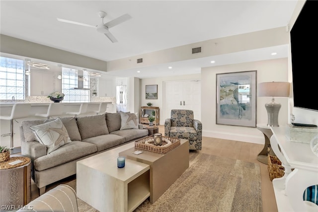 living room with ceiling fan and light hardwood / wood-style floors