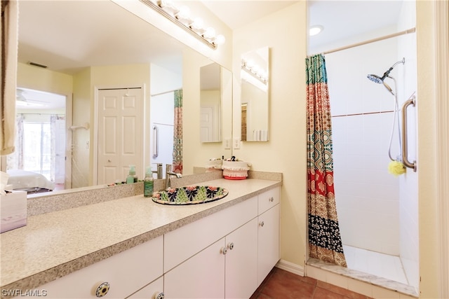 bathroom with walk in shower, vanity, and tile patterned flooring