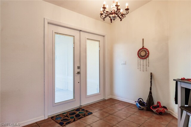 doorway with light tile patterned floors and a notable chandelier