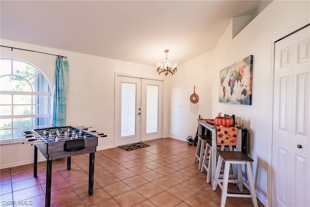 foyer featuring light tile patterned floors, french doors, and a notable chandelier