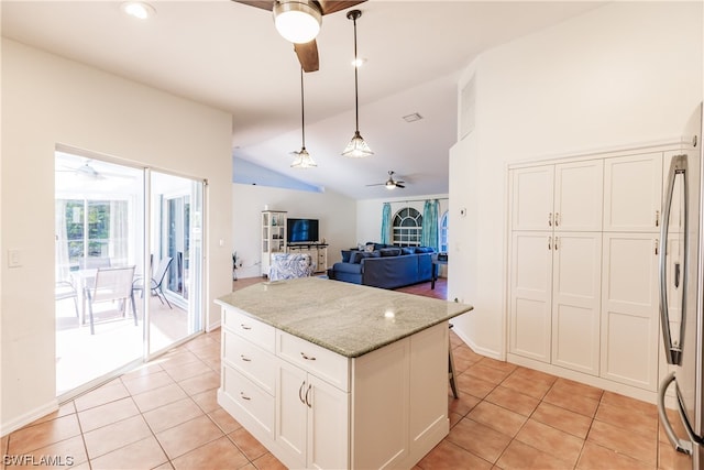 kitchen featuring vaulted ceiling, white cabinets, light stone countertops, ceiling fan, and decorative light fixtures