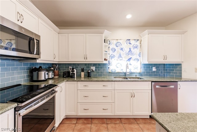 kitchen with decorative backsplash, white cabinetry, appliances with stainless steel finishes, and sink