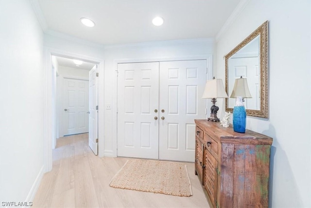 foyer featuring ornamental molding and light hardwood / wood-style floors