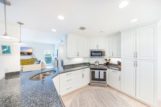 kitchen featuring pendant lighting, sink, white cabinets, and appliances with stainless steel finishes