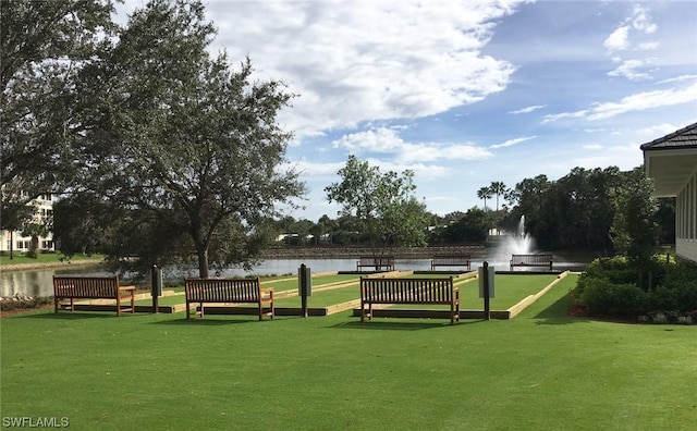 view of property's community featuring a lawn and a water view