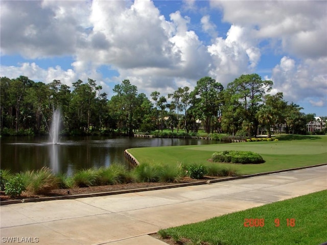 view of community featuring a water view and a lawn