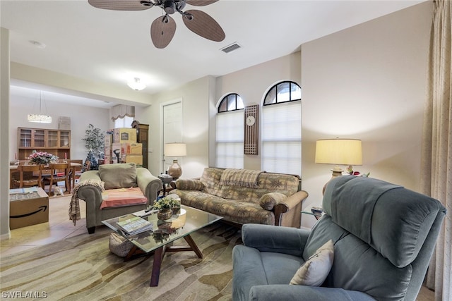 living room featuring light tile floors and ceiling fan