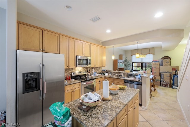 kitchen with stainless steel appliances, a notable chandelier, light tile floors, kitchen peninsula, and dark stone countertops