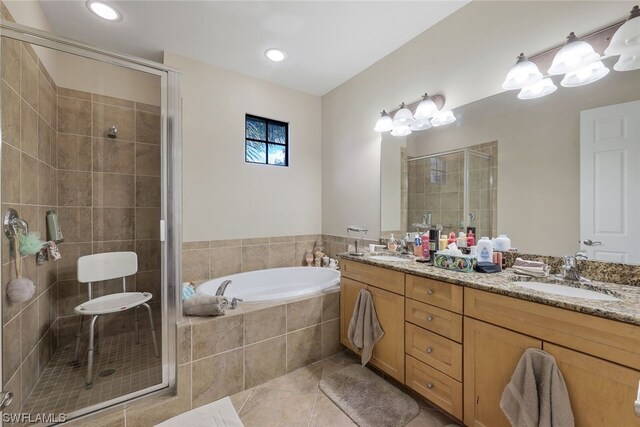 bathroom featuring double sink, tile flooring, large vanity, and separate shower and tub