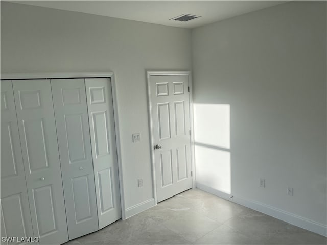 unfurnished bedroom with a closet and light tile flooring