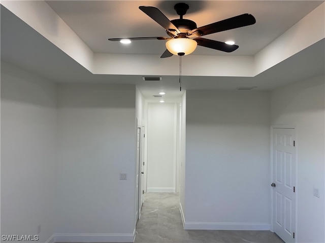 tiled spare room with a raised ceiling and ceiling fan