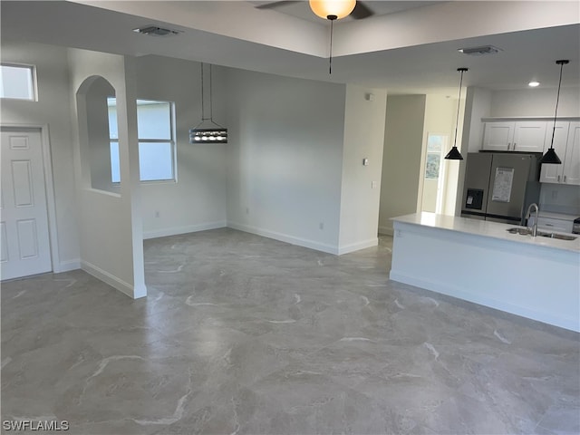 unfurnished living room with ceiling fan, light tile floors, and sink