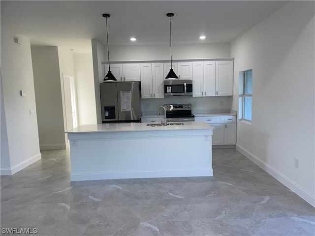 kitchen with a kitchen island with sink, pendant lighting, light tile floors, white cabinets, and appliances with stainless steel finishes