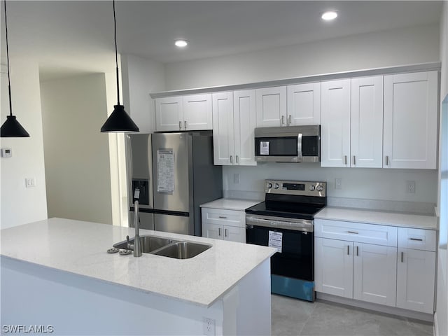 kitchen with light tile floors, white cabinets, pendant lighting, and stainless steel appliances