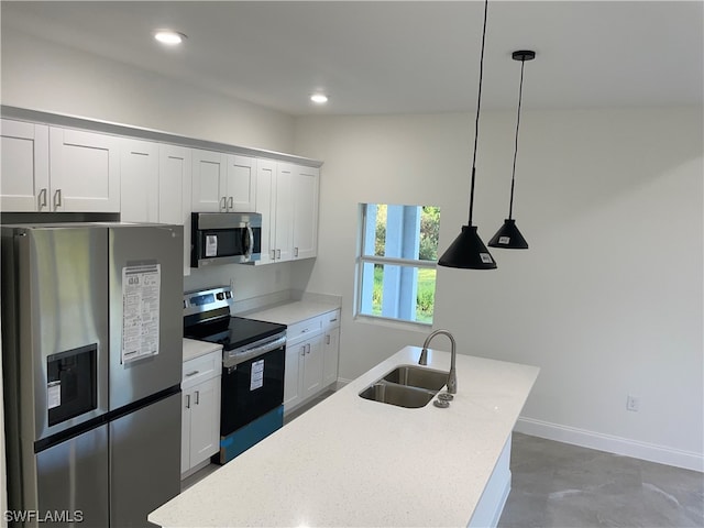 kitchen featuring white cabinetry, stainless steel appliances, pendant lighting, and sink