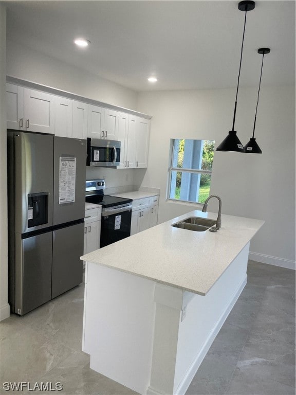 kitchen with pendant lighting, light stone countertops, appliances with stainless steel finishes, a kitchen island with sink, and sink