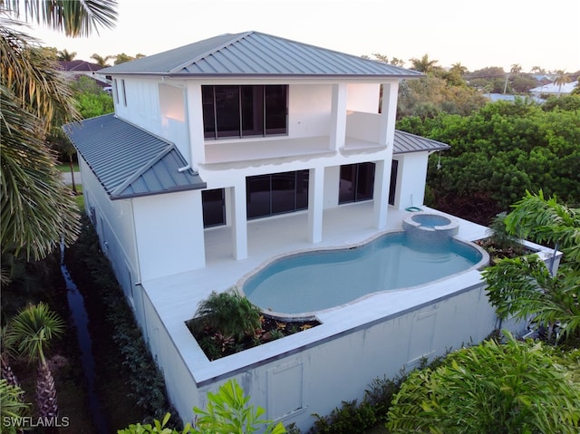 back house at dusk featuring a patio area