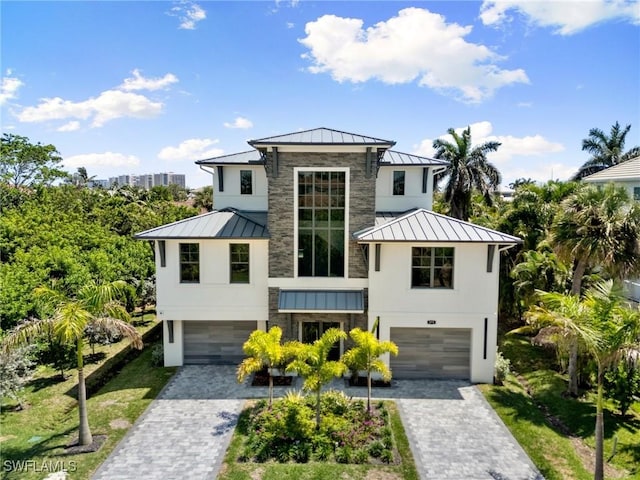 375 Periwinkle Ct, Marco Island, FL 34145 - view of front of house with metal roof, a standing seam roof, a garage, and decorative driveway