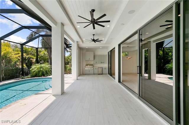 375 Periwinkle Ct, Marco Island, FL 34145 - view of swimming pool with a ceiling fan, an outdoor kitchen, a fenced in pool, a patio area, and glass enclosure