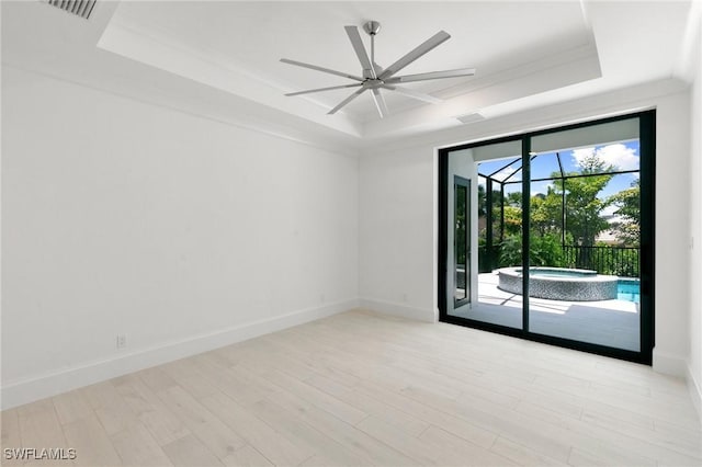 375 Periwinkle Ct, Marco Island, FL 34145 - empty room with a ceiling fan, a tray ceiling, baseboards, a sunroom, and wood finished floors