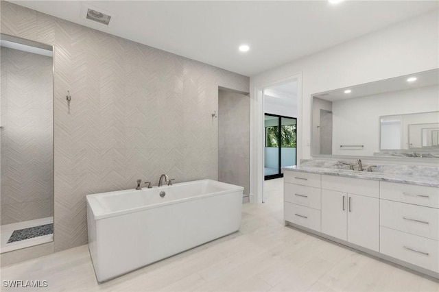 375 Periwinkle Ct, Marco Island, FL 34145 - bathroom with vanity, a freestanding bath, visible vents, and recessed lighting
