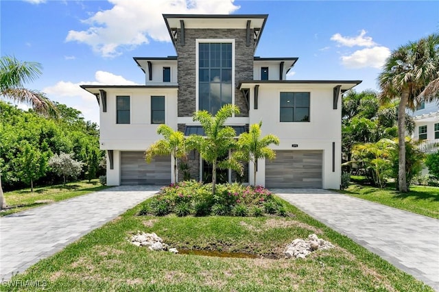 375 Periwinkle Ct, Marco Island, FL 34145 - contemporary house with stone siding, decorative driveway, stucco siding, and an attached garage