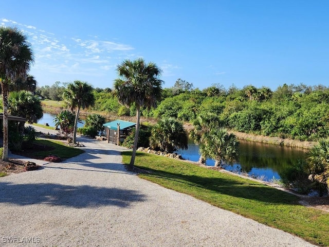 view of property's community with a water view and a yard