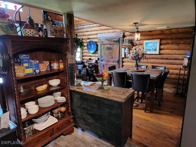 bar with wood-type flooring and rustic walls