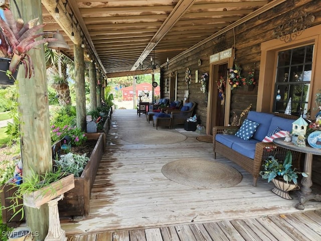 wooden deck with an outdoor hangout area and covered porch