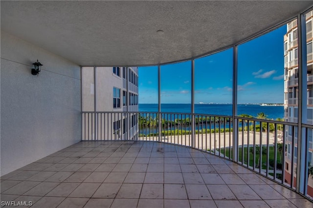 unfurnished sunroom with a water view