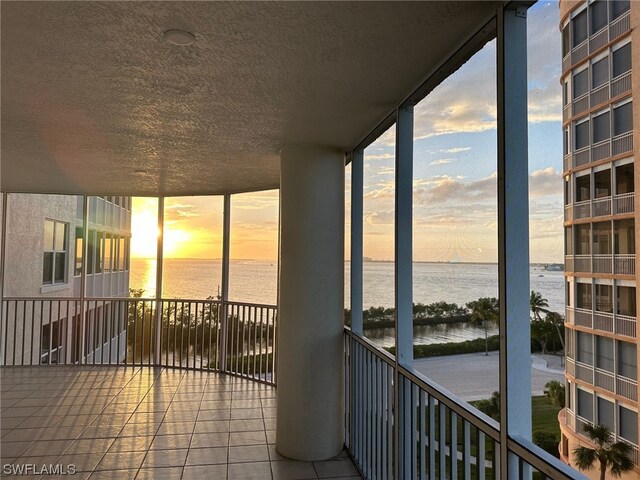 sunroom with a water view and a healthy amount of sunlight