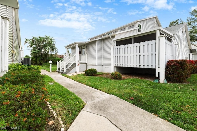 view of side of home featuring a lawn and central AC unit