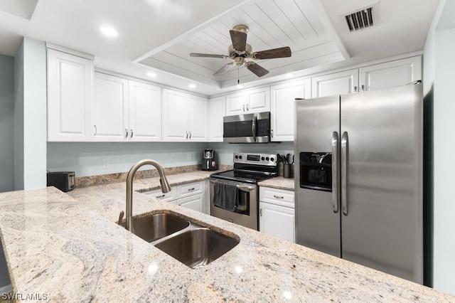 kitchen featuring light stone counters, sink, white cabinets, and stainless steel appliances