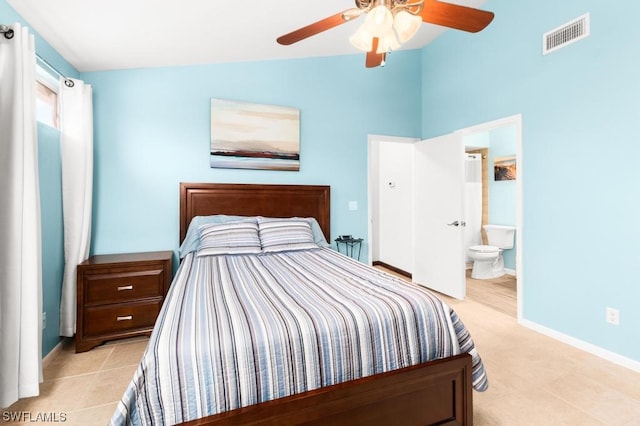 bedroom featuring ceiling fan, light tile patterned floors, connected bathroom, and vaulted ceiling