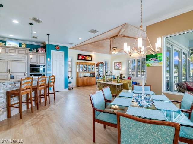 dining room featuring crown molding, light hardwood / wood-style flooring, and a notable chandelier