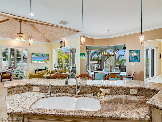 kitchen featuring a wealth of natural light, sink, hanging light fixtures, light stone counters, and wood ceiling