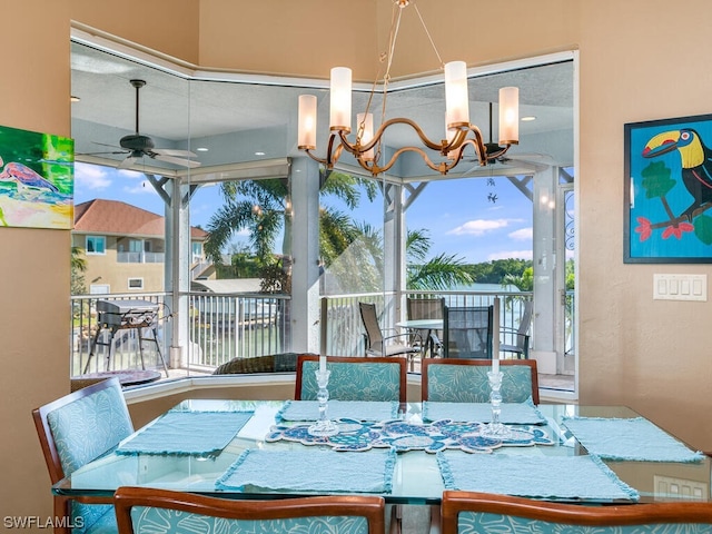 dining space featuring ceiling fan with notable chandelier