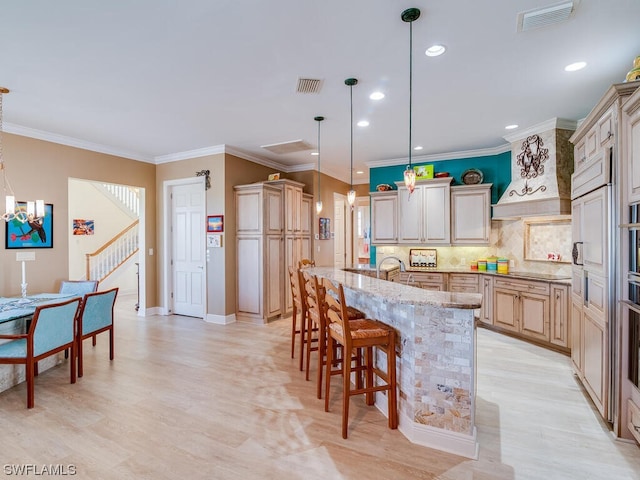 kitchen with light stone counters, pendant lighting, a kitchen bar, decorative backsplash, and a kitchen island