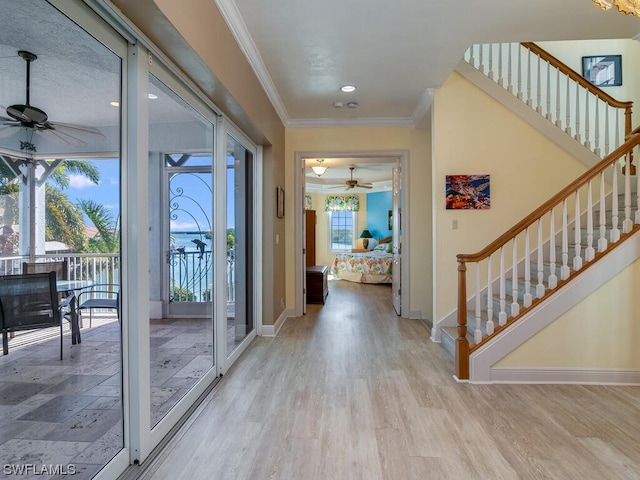 entrance foyer with light hardwood / wood-style floors, ceiling fan, and crown molding