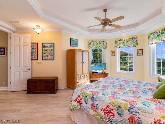 bedroom with a raised ceiling, ceiling fan, ornamental molding, and light wood-type flooring