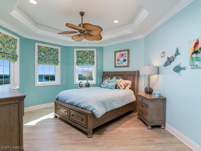 bedroom with light hardwood / wood-style flooring, a raised ceiling, ceiling fan, and ornamental molding