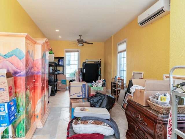 storage room with a wall unit AC and ceiling fan