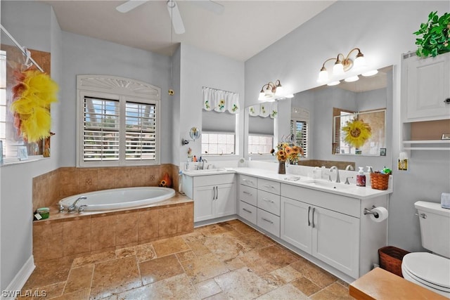 bathroom featuring vanity, ceiling fan, toilet, and tiled tub