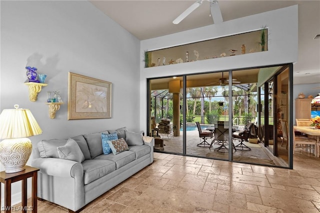 living room with a towering ceiling and ceiling fan