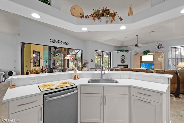 kitchen with dishwasher, lofted ceiling, sink, ceiling fan, and white cabinetry