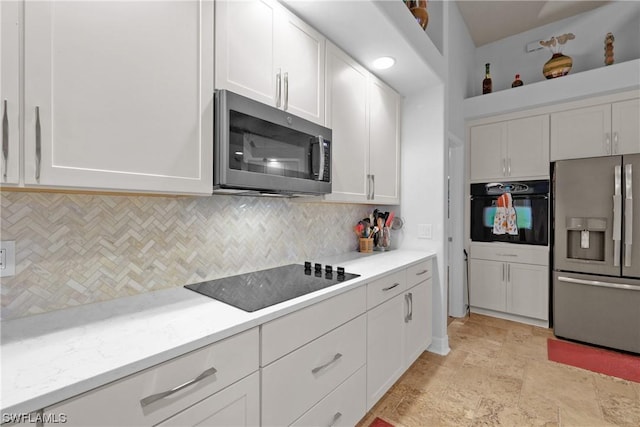 kitchen featuring white cabinetry, decorative backsplash, light stone countertops, and black appliances