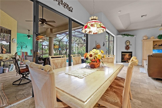 dining space with ceiling fan and a tray ceiling