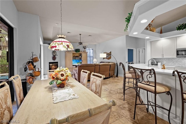 dining area featuring ceiling fan and sink