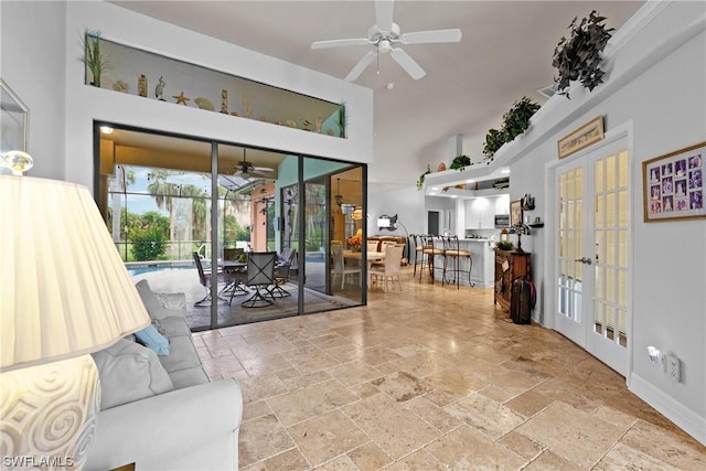 living room featuring french doors, ceiling fan, and a high ceiling